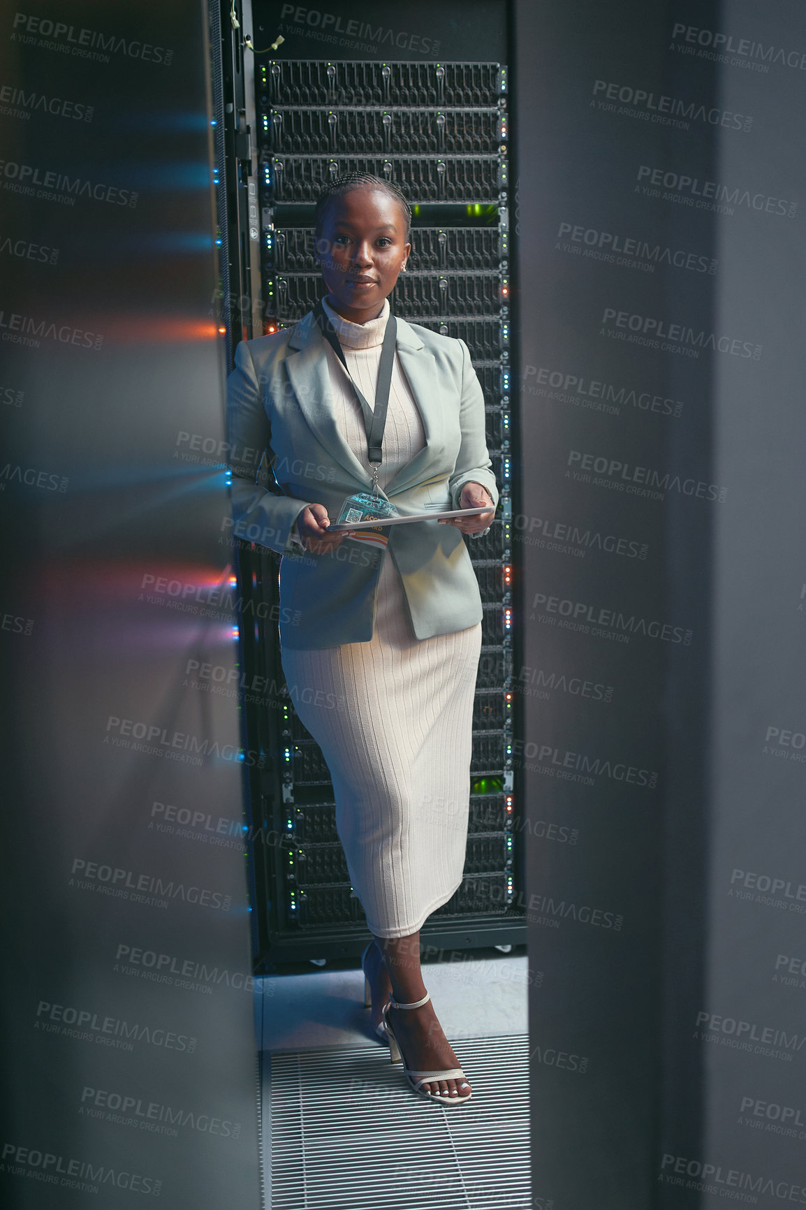 Buy stock photo Full length shot of a young IT specialist standing alone in the server room and using a digital tablet