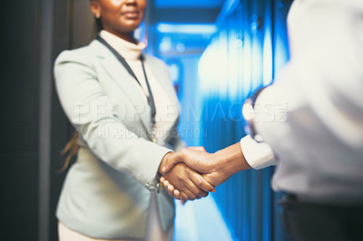 Buy stock photo Cropped shot of two unrecognizable IT specialists standing together in the server room and shaking hands