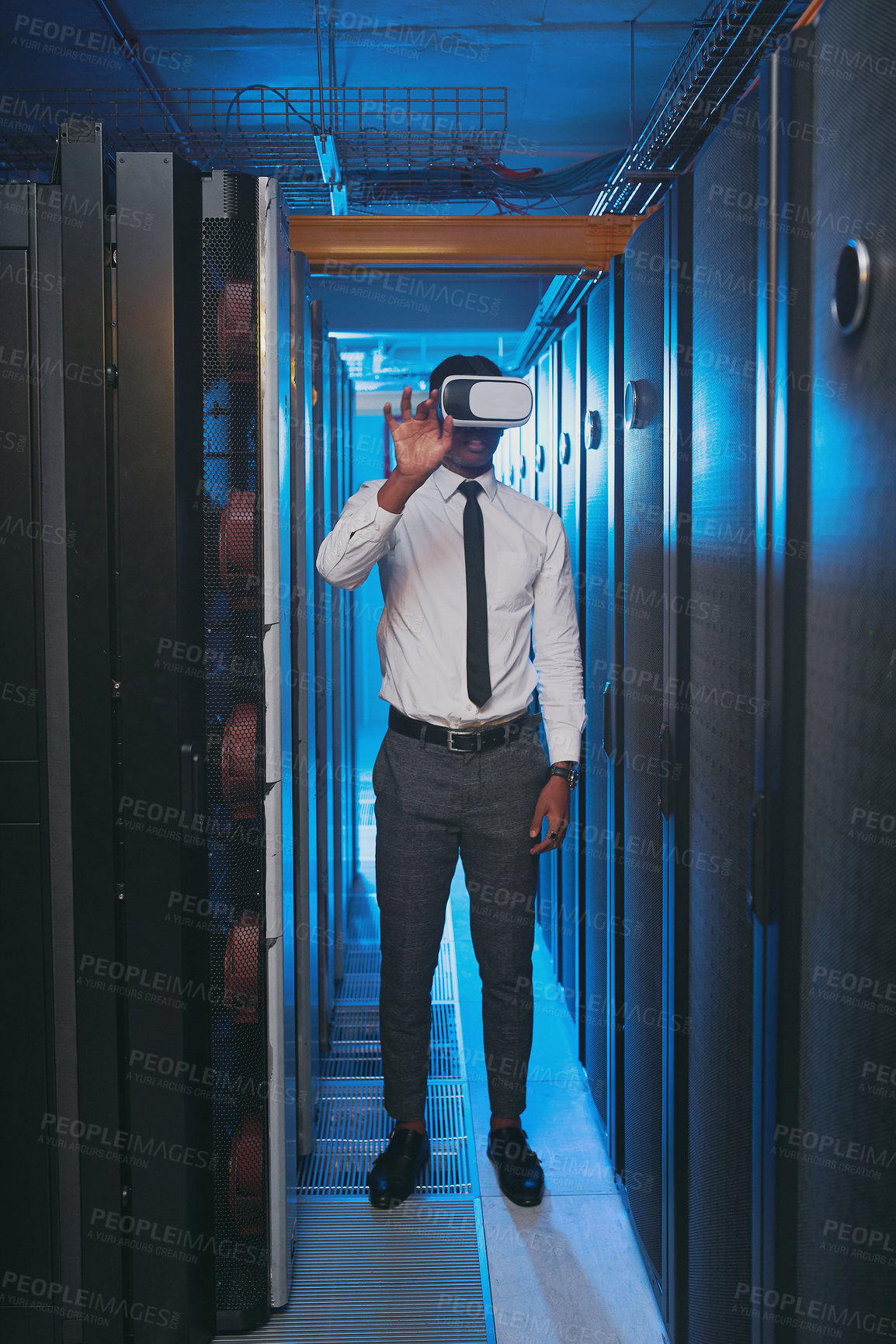 Buy stock photo Full length shot of a young IT specialist standing alone in the server room and wearing a virtual reality headset