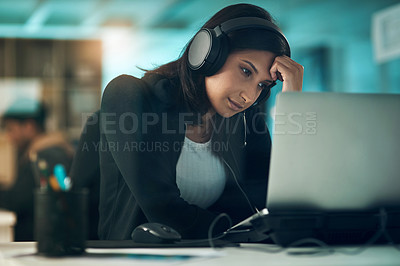 Buy stock photo Shot of an exhausted young woman using a headset in a modern office