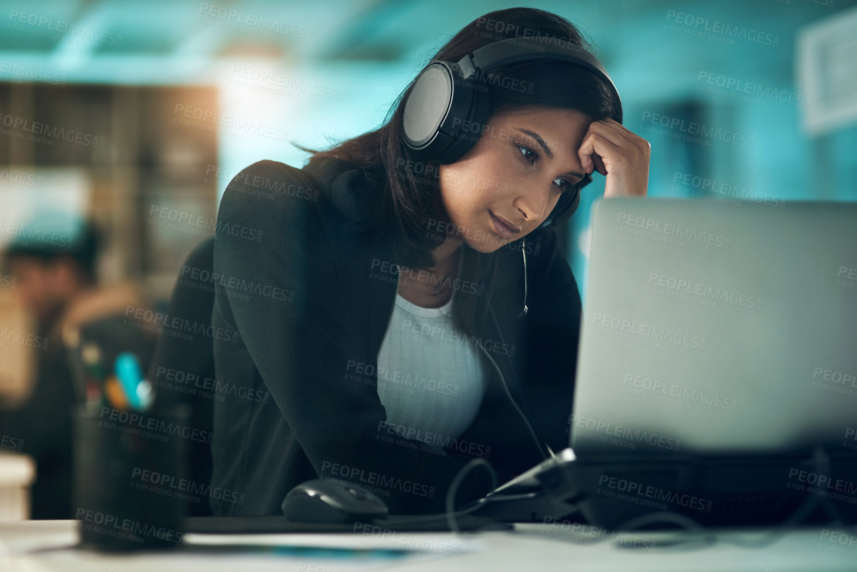 Buy stock photo Shot of an exhausted young woman using a headset in a modern office