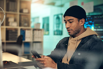 Buy stock photo Shot of a young man using a cellphone in a modern office