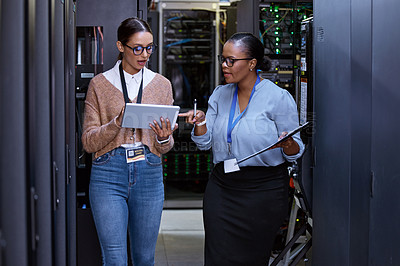 Buy stock photo Talking, server room and women with a tablet for cyber security, database planning and inspection. Teamwork, technician and female programmers speaking with technology for coding, hardware and system