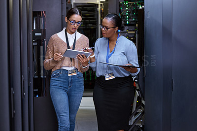 Buy stock photo Talking, server room and women with a tablet for cyber security, database planning and inspection. Teamwork, technician and female programmers talking with technology for coding, hardware and system