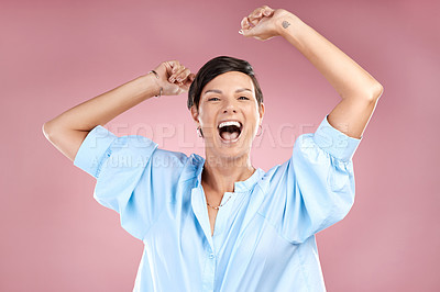 Buy stock photo Cropped portrait of an attractive young woman cheering in studio against a pink background