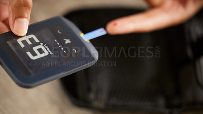 Buy stock photo High angle shot of an unrecognizable woman testing her blood sugar level at home