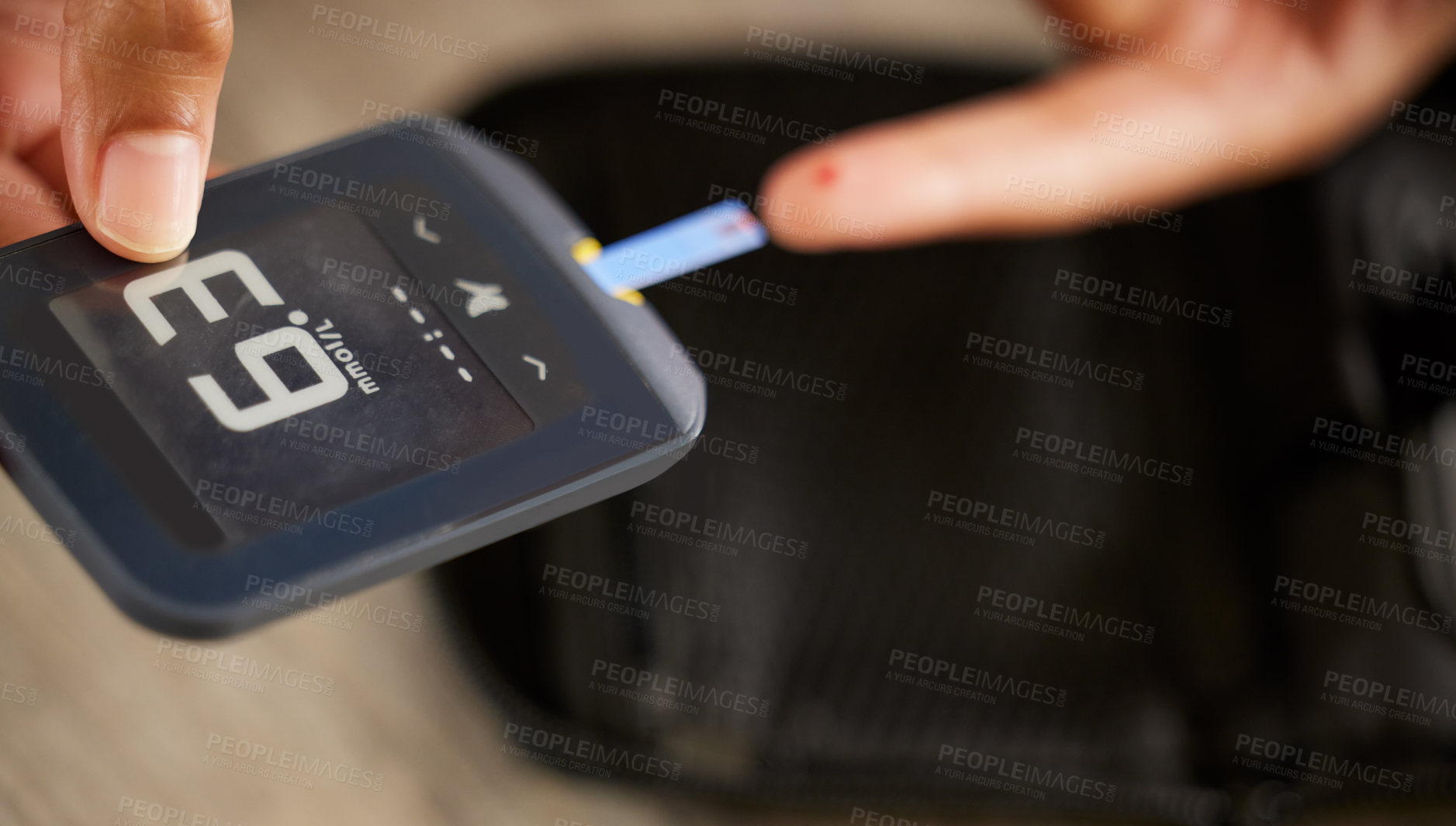 Buy stock photo High angle shot of an unrecognizable woman testing her blood sugar level at home