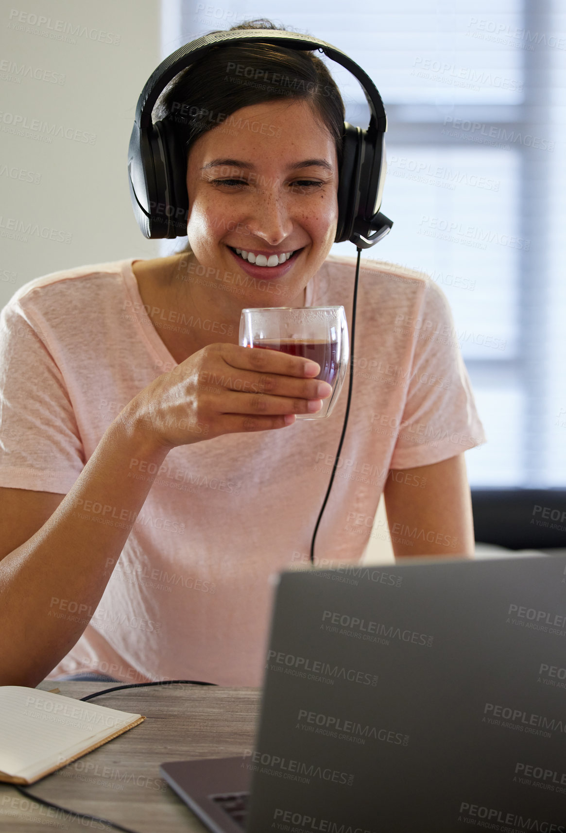 Buy stock photo Shot of a young woman drinking tea while working from home