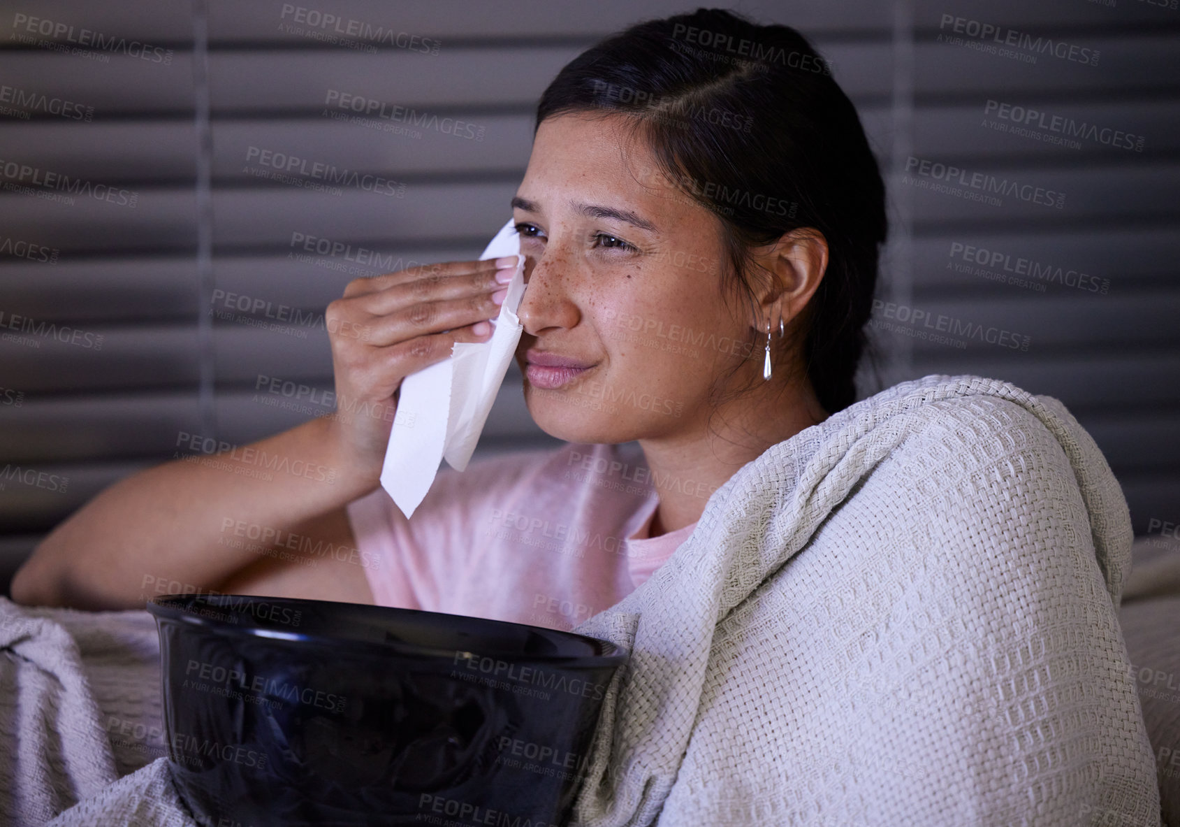 Buy stock photo Shot of a young woman crying while watching tv at home
