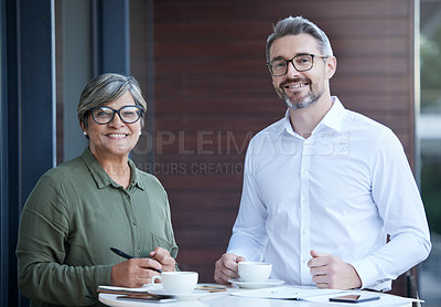 Buy stock photo Shot of two businesspeople going through paperwork at work