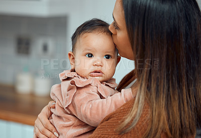 Buy stock photo Cropped shot of an unrecognizable young woman kissing her newborn baby on the forehead at home