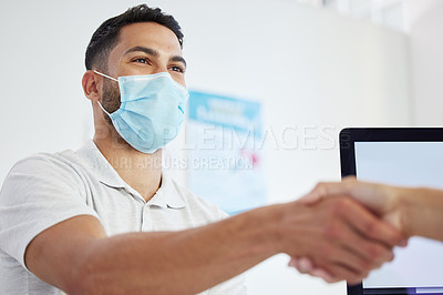 Buy stock photo Shot of a young man sitting and shaking hands with his doctor during a consult in the clinic