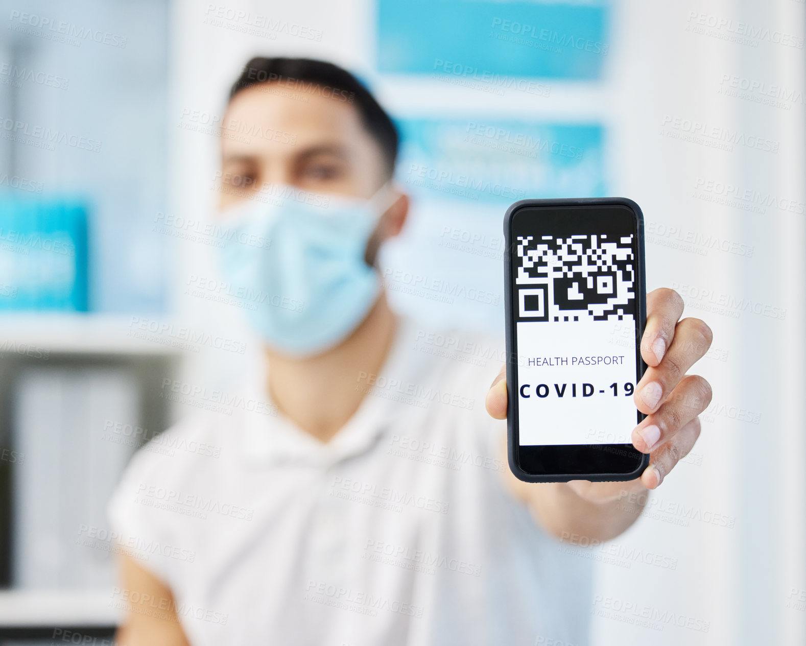Buy stock photo Shot of an unrecognizable man sitting alone in the clinic and showing his Covid vaccine passport on his cellphone