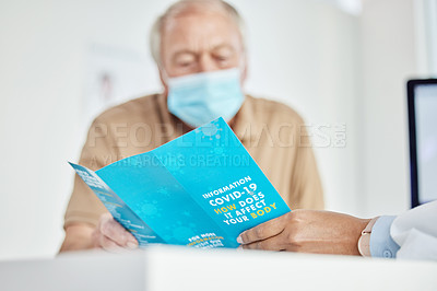 Buy stock photo Shot of a senior man sitting with his doctor and looking at a leaflet during a consult in the clinic