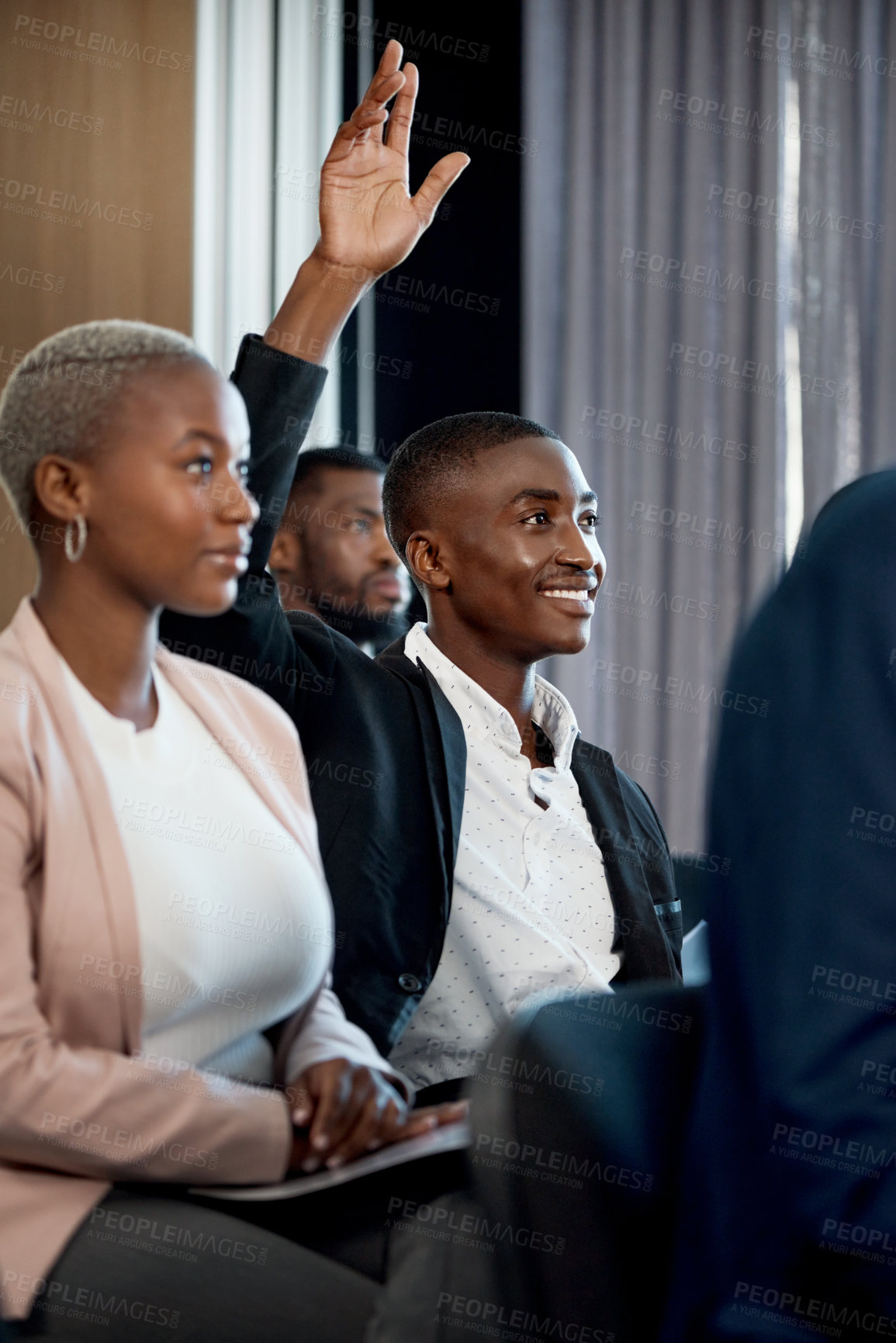 Buy stock photo Shot of a young businessman raising his hand during a conference in a modern office