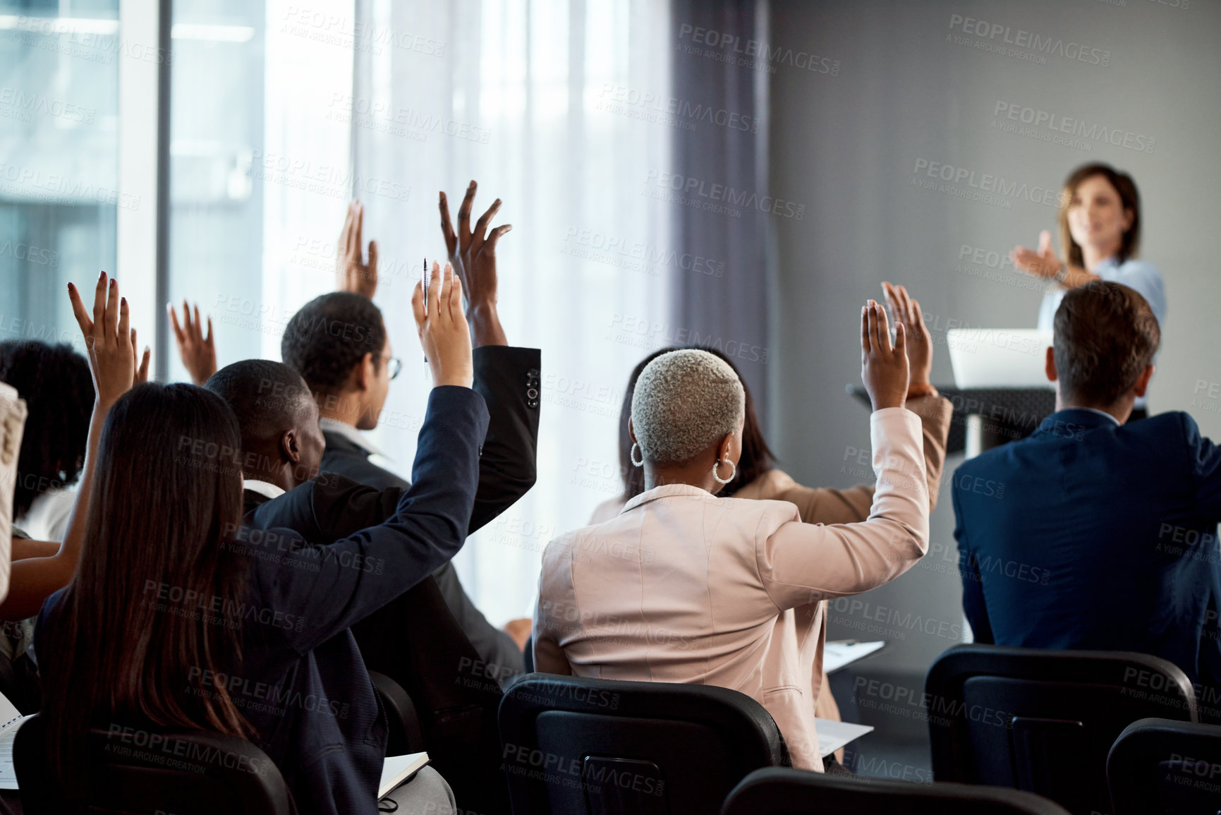 Buy stock photo Rearview shot of a group of businesspeople raising their hands during a conference