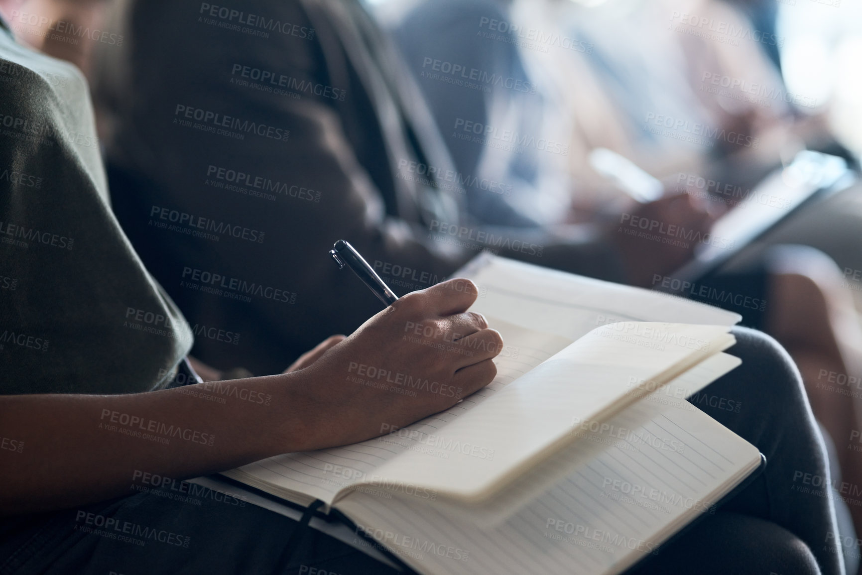 Buy stock photo Shot of a group of unrecognizable businesspeople taking notes during a meeting in an office