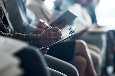 Buy stock photo Shot of a group of unrecognizable businesspeople taking notes during a meeting in an office