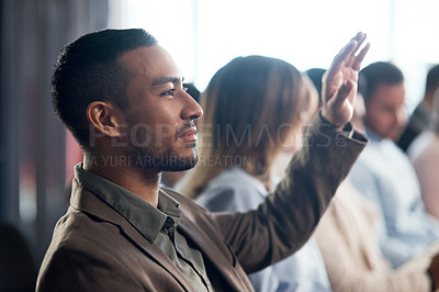 Buy stock photo Shot of a young businessman raising his hand during a conference in a modern office