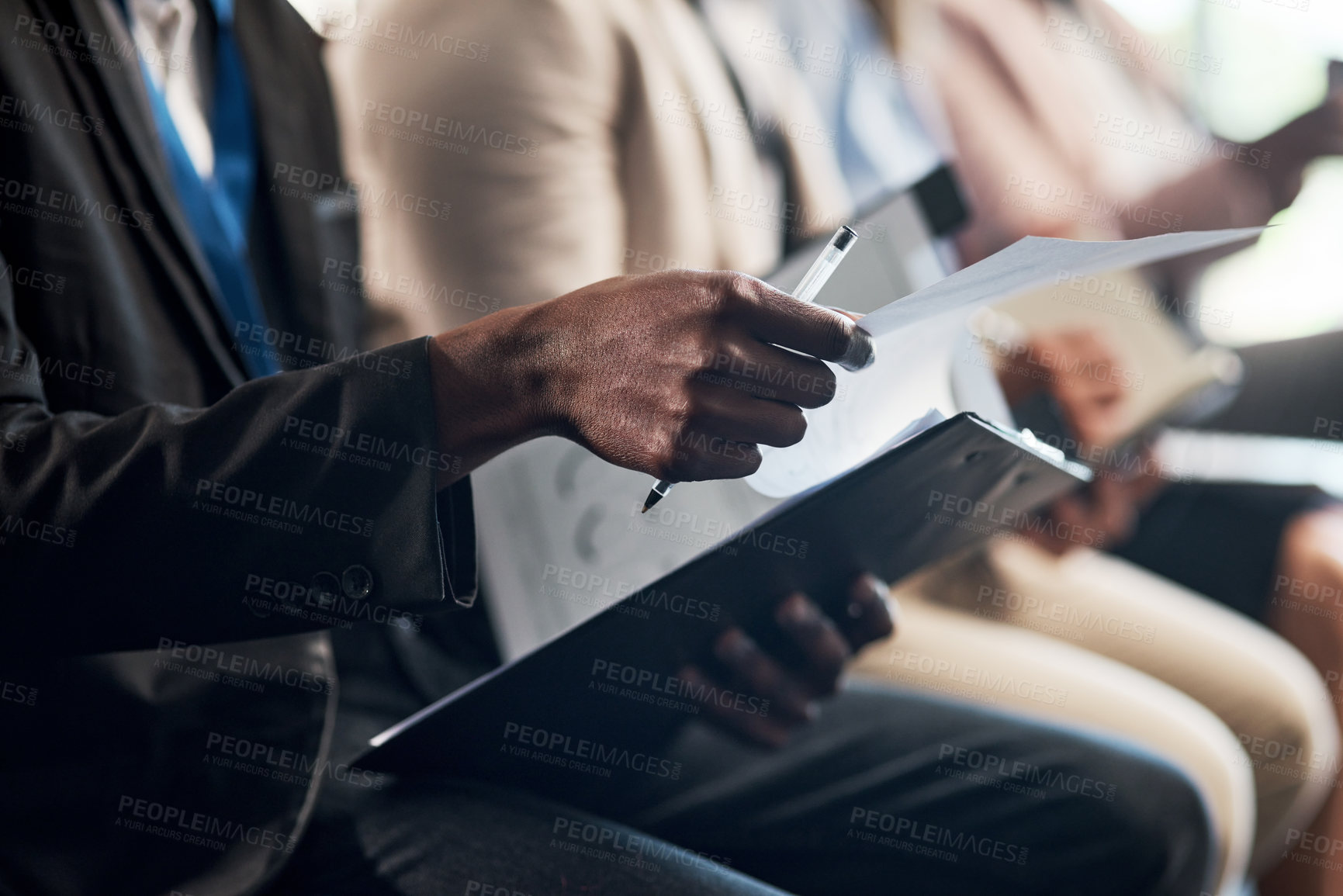 Buy stock photo Shot of a group of unrecognizable businesspeople taking notes during a meeting in an office