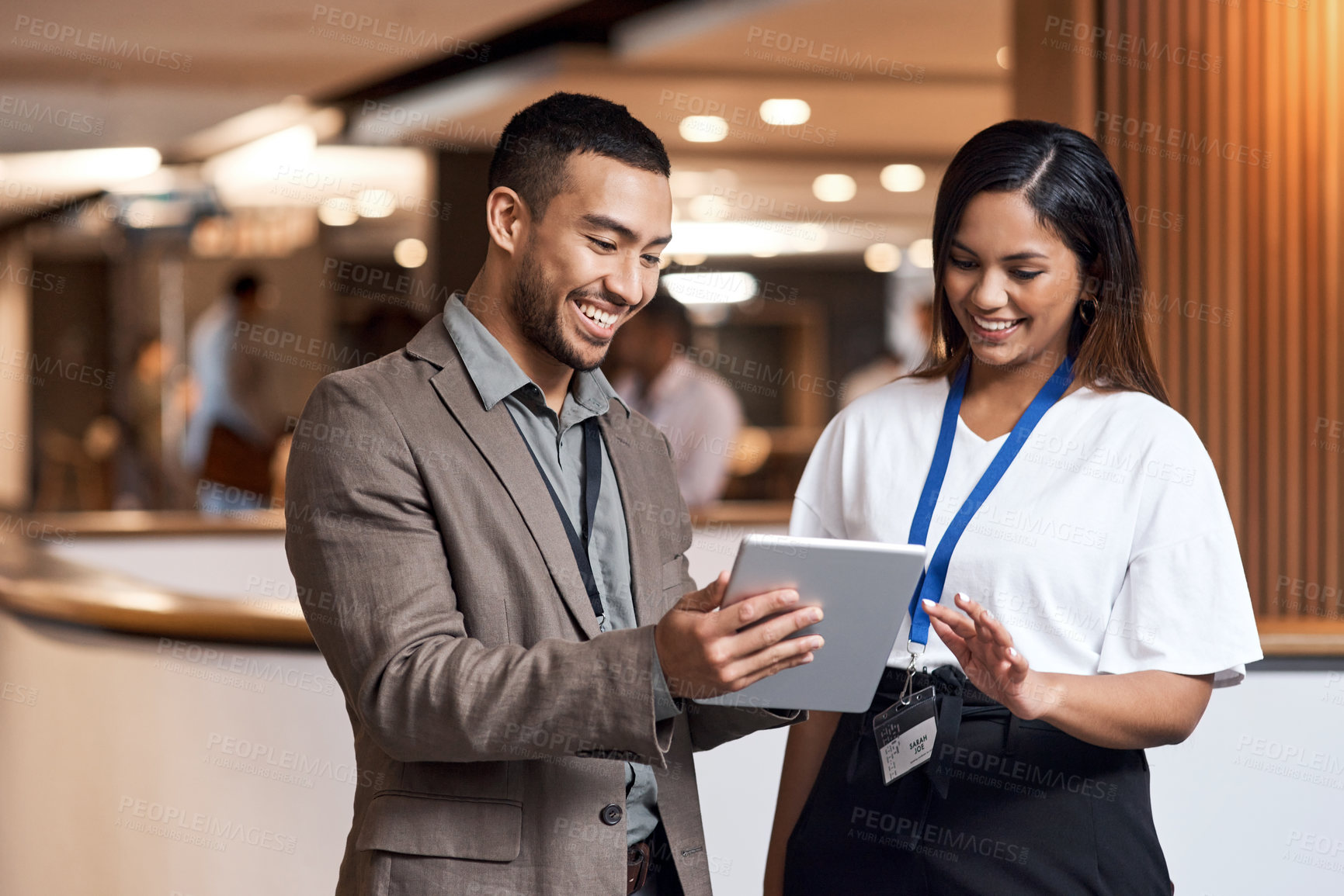 Buy stock photo Shot of a young businessman and businesswoman using a digital tablet at a conference