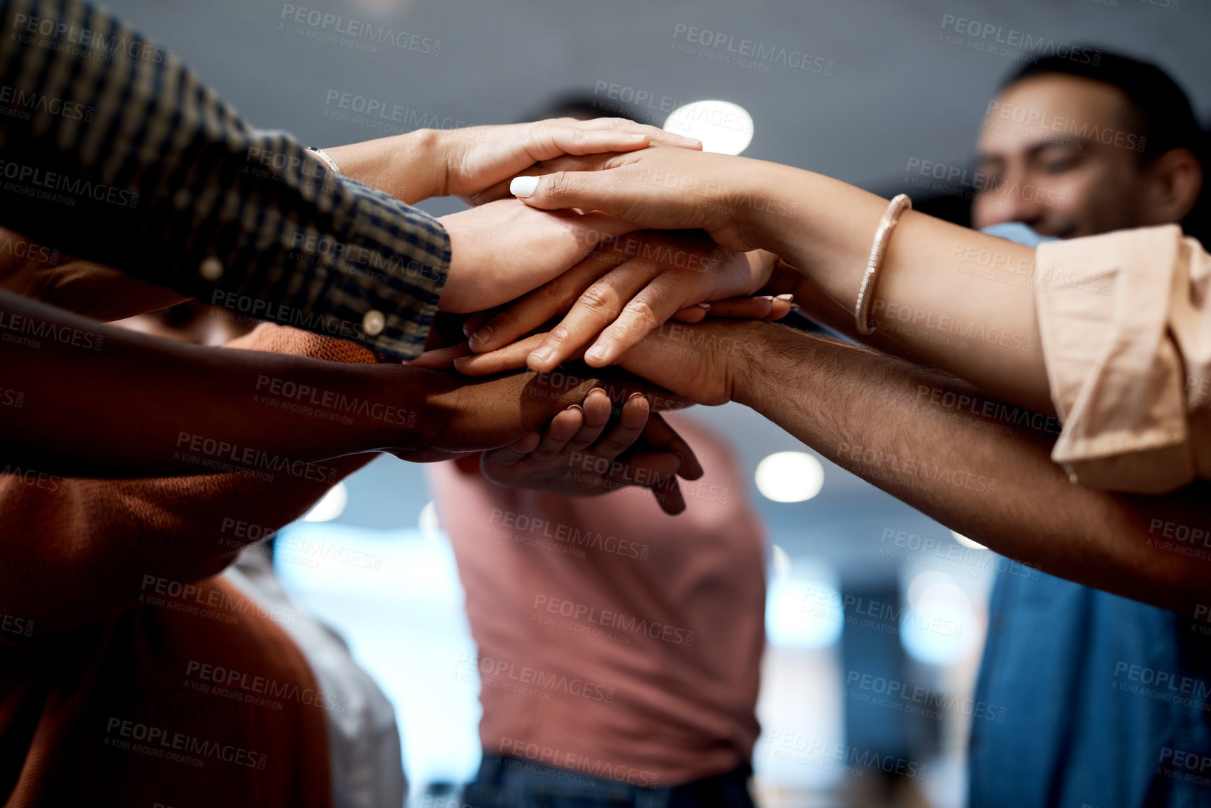 Buy stock photo Shot of a group of businesspeople joining hands in solidarity in a modern office