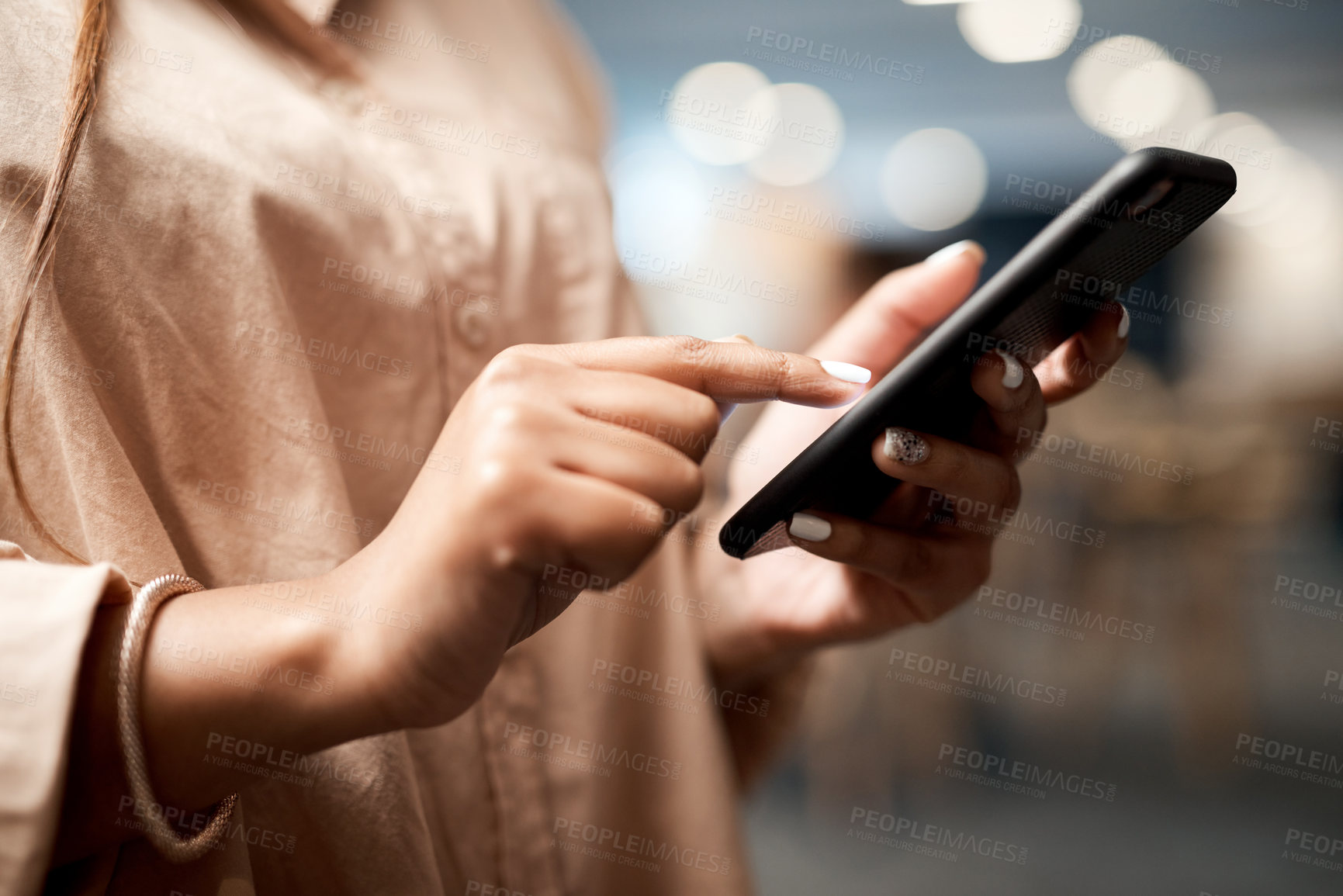 Buy stock photo Shot of an unrecognisable businesswoman using a smartphone in a modern office