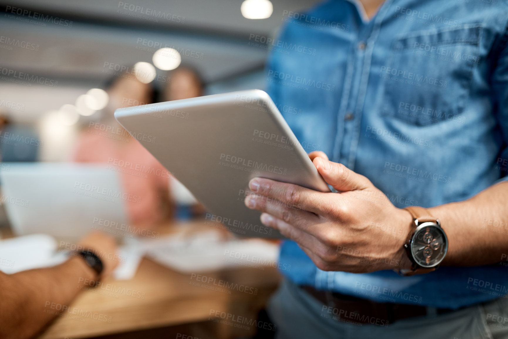 Buy stock photo Shot of an unrecognisable businessman using a digital tablet during a conference in a modern office