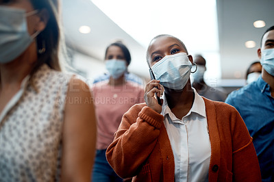 Buy stock photo Shot of a masked young businesswoman using a smartphone during a conference