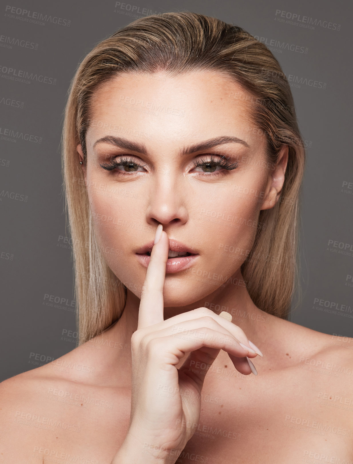 Buy stock photo Woman, secret and finger in lips for skincare in studio with beauty, sign and hush on gray background, Girl, portrait and hand gesture for silence, natural makeup or cosmetics with  glow in Australia