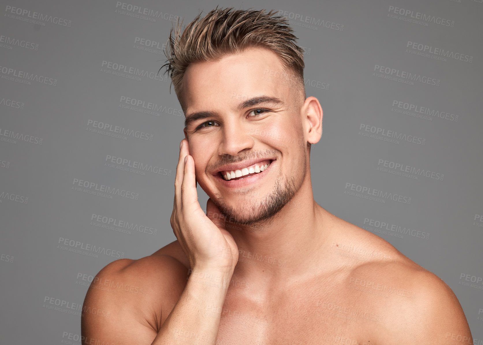 Buy stock photo Studio shot of a handsome young man posing against a grey background