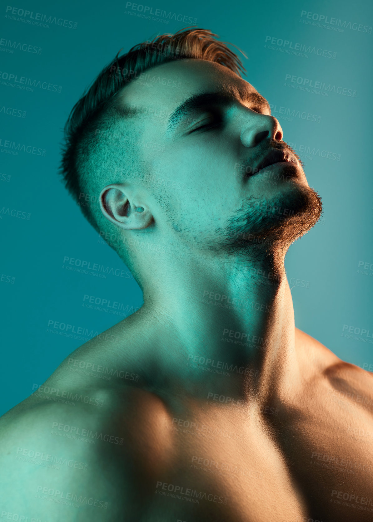 Buy stock photo Studio shot of a handsome young man posing against a blue background