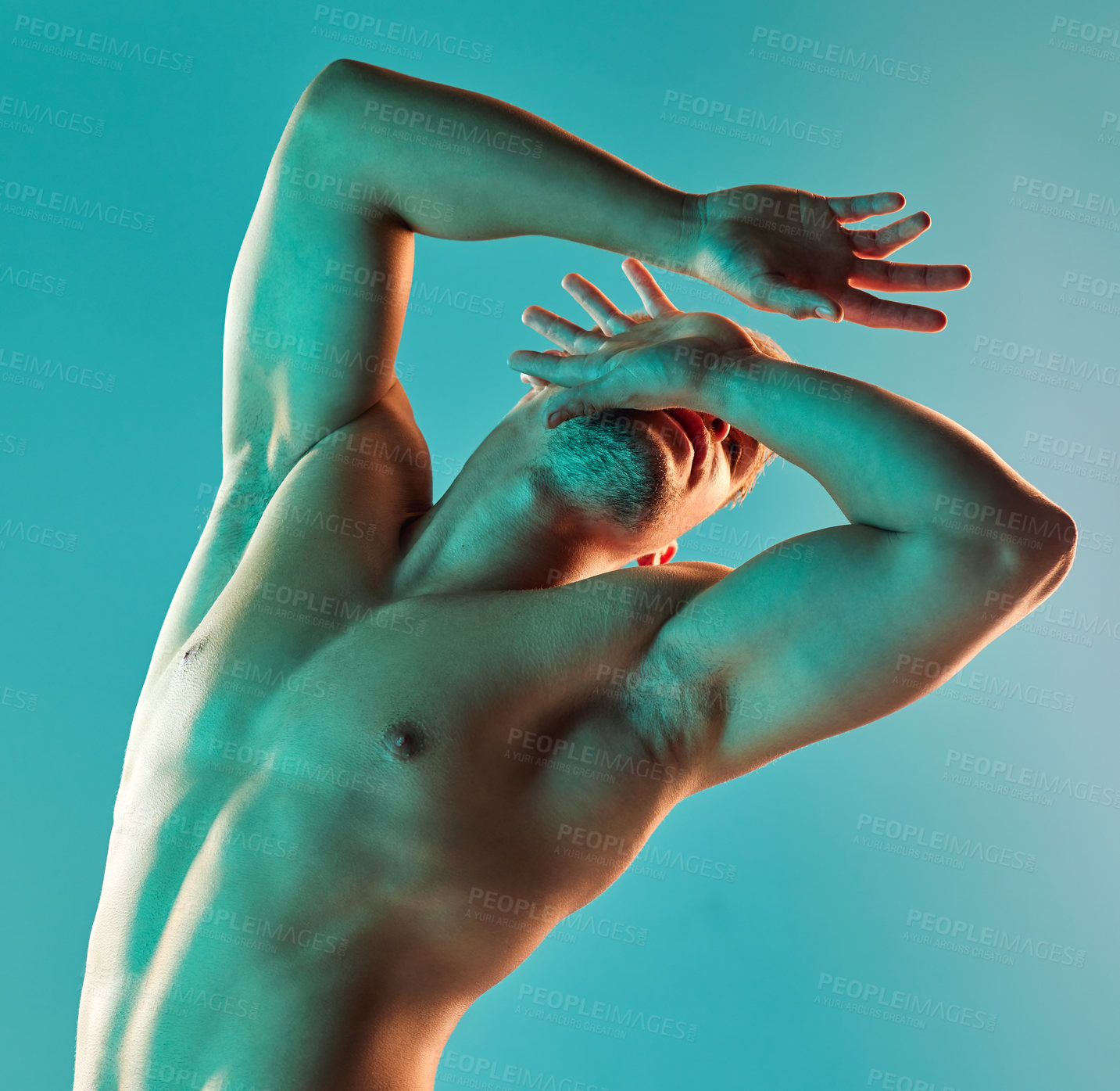 Buy stock photo Studio shot of a handsome young man posing against a blue background