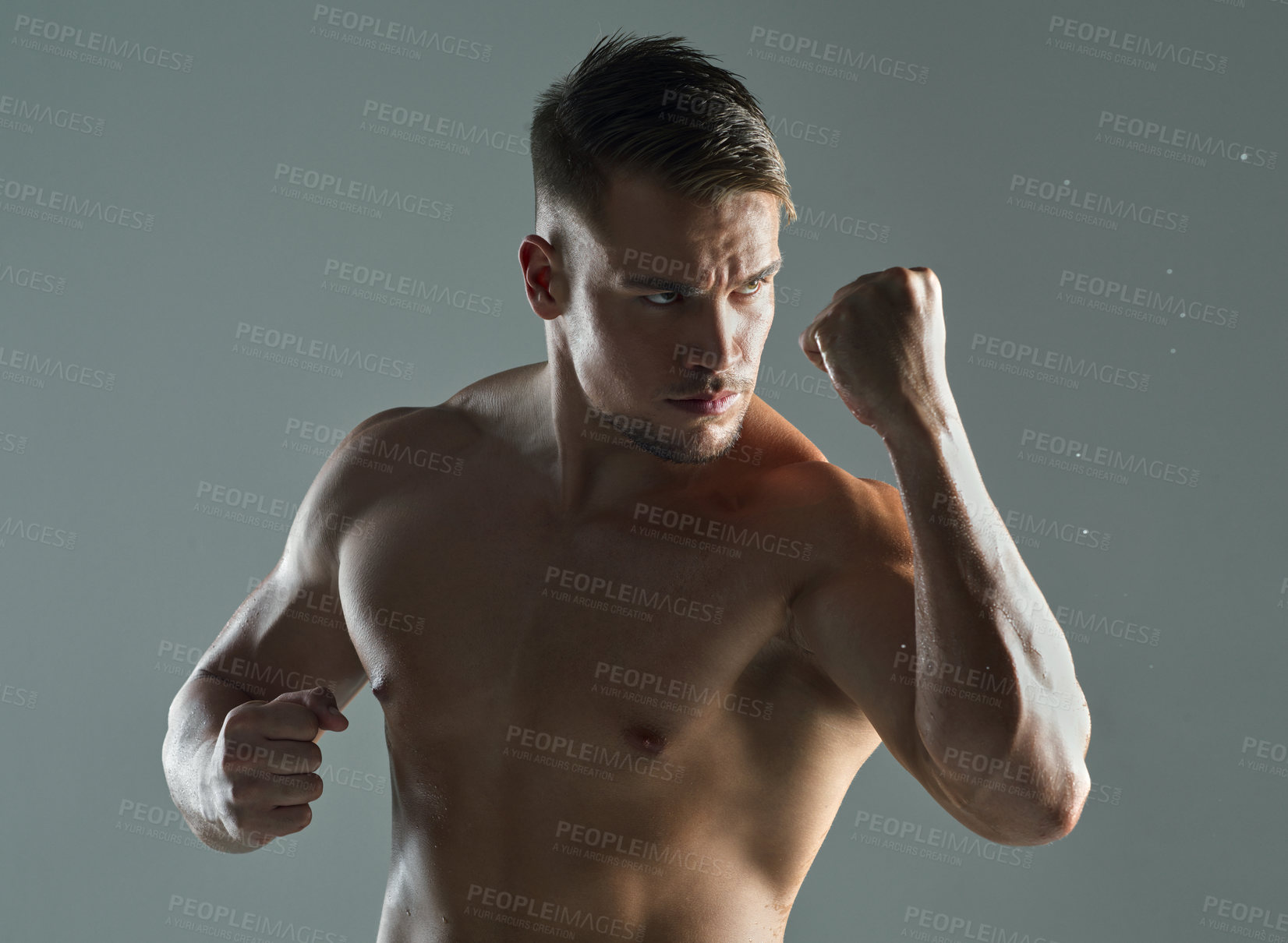 Buy stock photo Shot of a young man practicing  his punches against a studio background