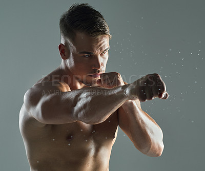 Buy stock photo Shot of a young man practicing  his punches against a studio background