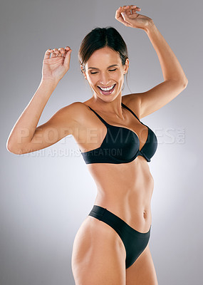 Buy stock photo Cropped shot of an attractive young woman posing in her underwear against a grey background in studio