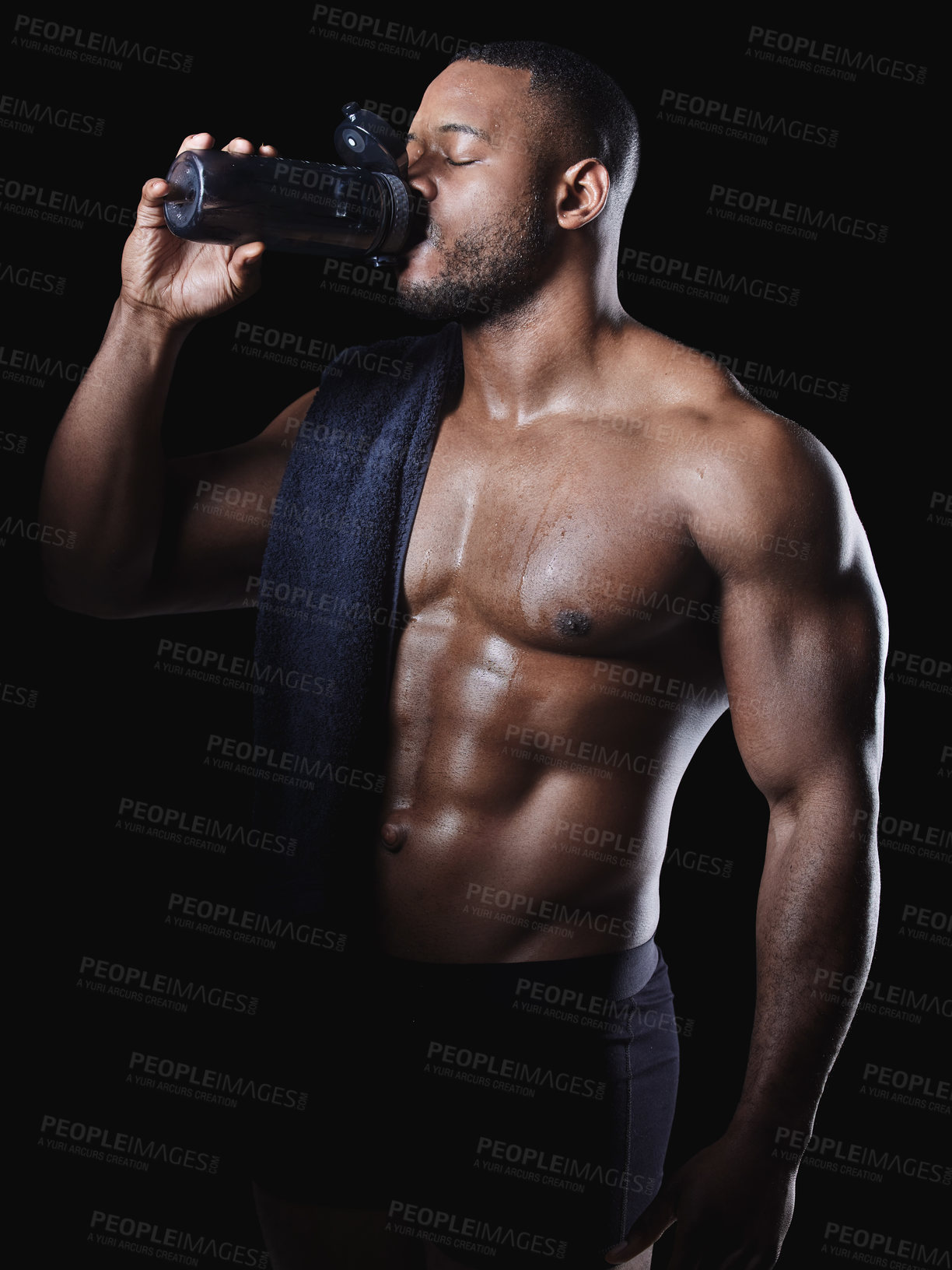 Buy stock photo Black man, drink and water or protein shake in studio for hydration, exercise and fitness or workout. Bodybuilder, wellness and liquid by dark background for African athlete, towel and heath