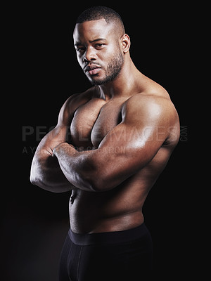 Buy stock photo Studio portrait of a fit young man posing against a black background
