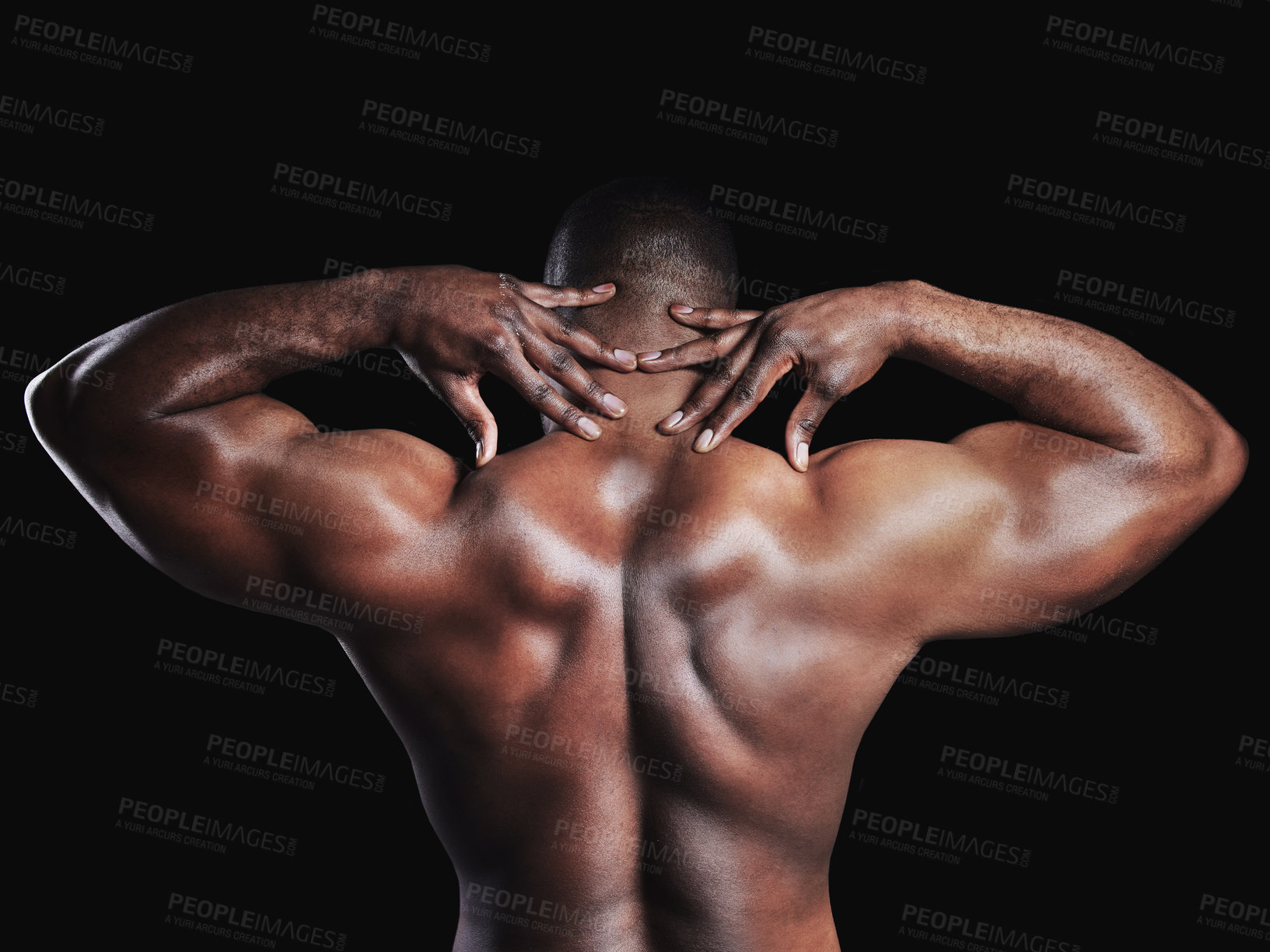 Buy stock photo Rearview studio shot of a fit young man flexing against a black background