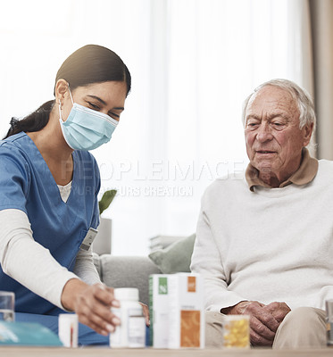 Buy stock photo Shot of a young female nurse helping a patient with their medication during a checkup at home