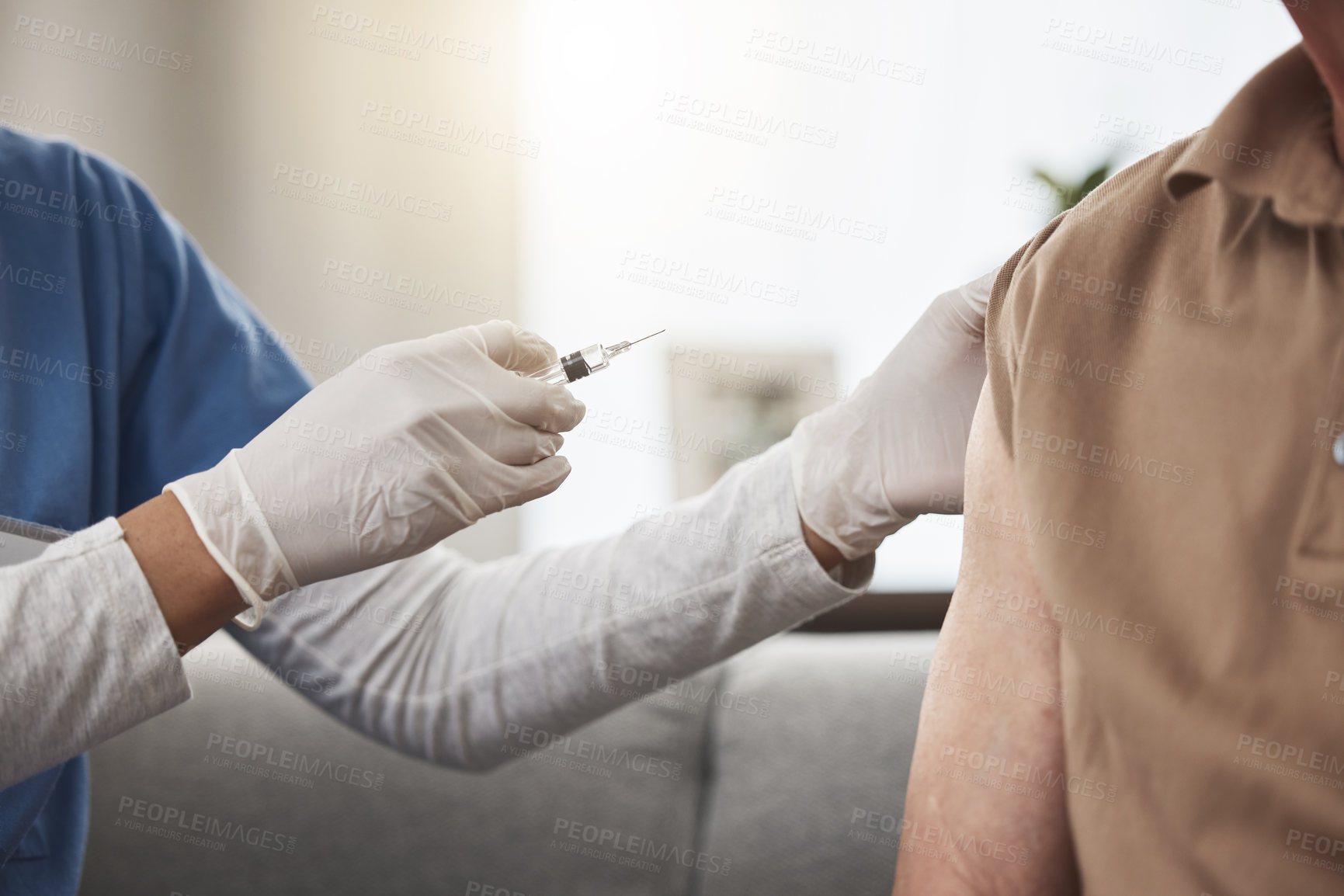 Buy stock photo Shot of an unrecognizable nurse giving a patient the vaccine at home