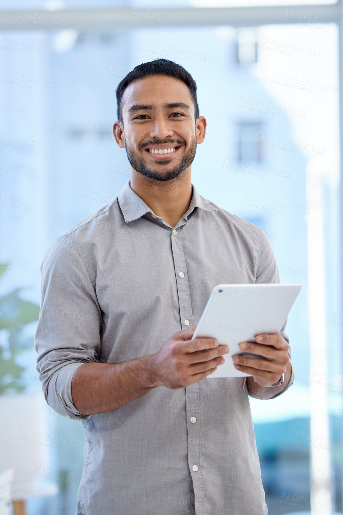 Buy stock photo Portrait of a young businessman using a digital tablet in an office