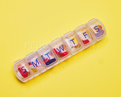 Buy stock photo Studio shot of a pill box against a yellow background
