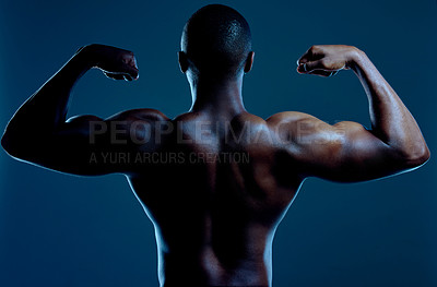 Buy stock photo Flexing, man and back in studio for fitness, wellness and progress or results from exercise. Athlete, bodybuilder and arms or biceps by blue background for workout, muscles and training for show 