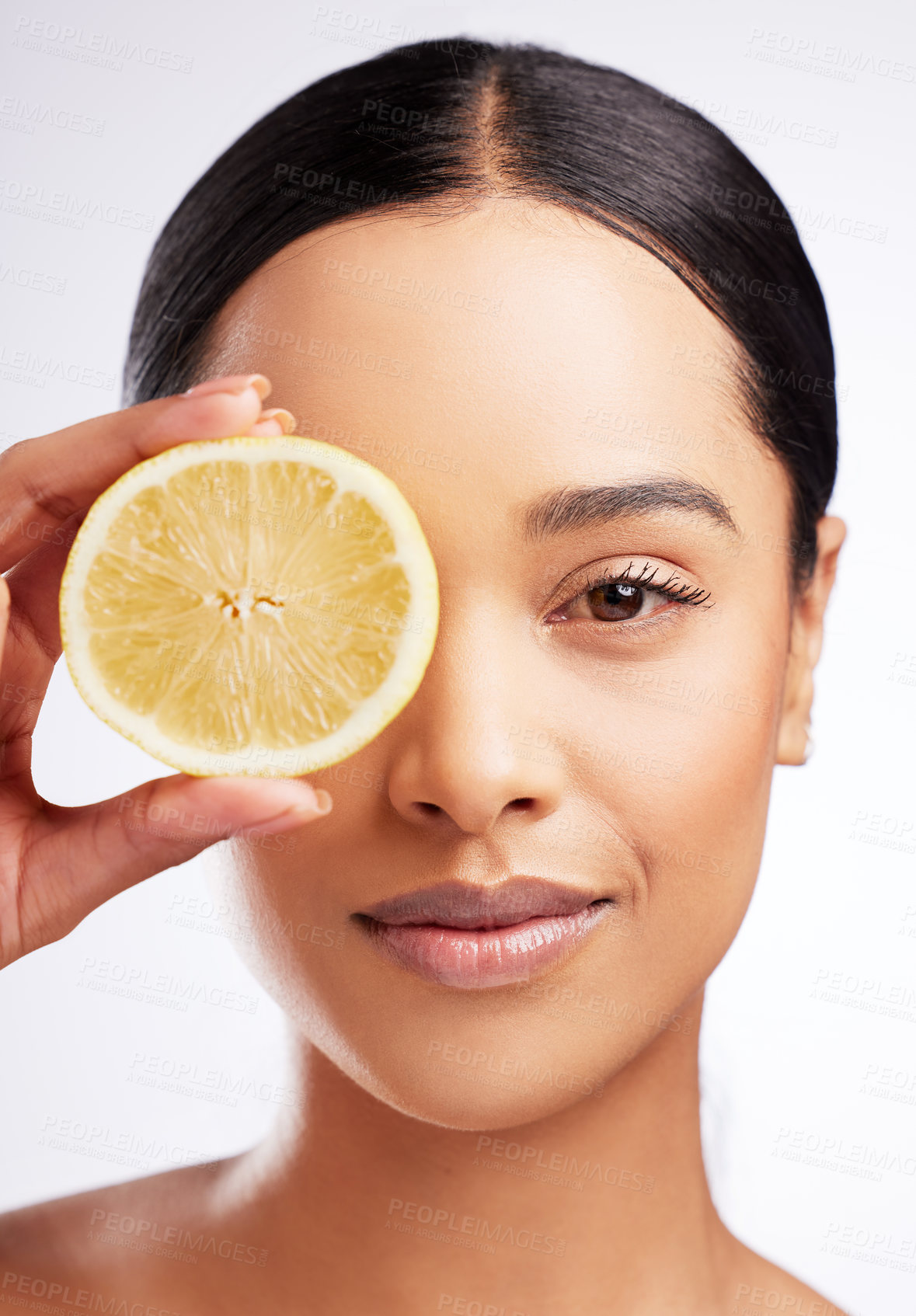 Buy stock photo Studio portrait of a beautiful young woman posing with a lemon against a white background