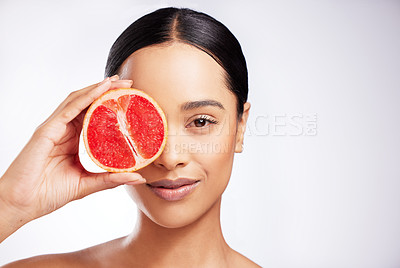Buy stock photo Studio portrait of a beautiful young woman posing with a grapefruit against a white background