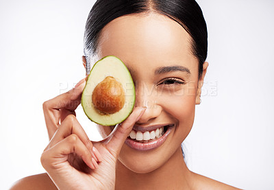 Buy stock photo Studio portrait of a beautiful young woman posing with an avocado against a white background