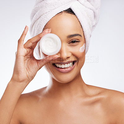 Buy stock photo Studio portrait of a beautiful young woman holding a tub of moisturiser against a white background