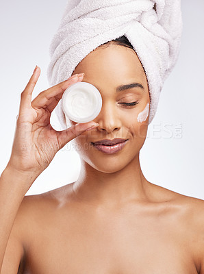 Buy stock photo Studio shot of a beautiful young woman holding a tub of moisturiser against a white background