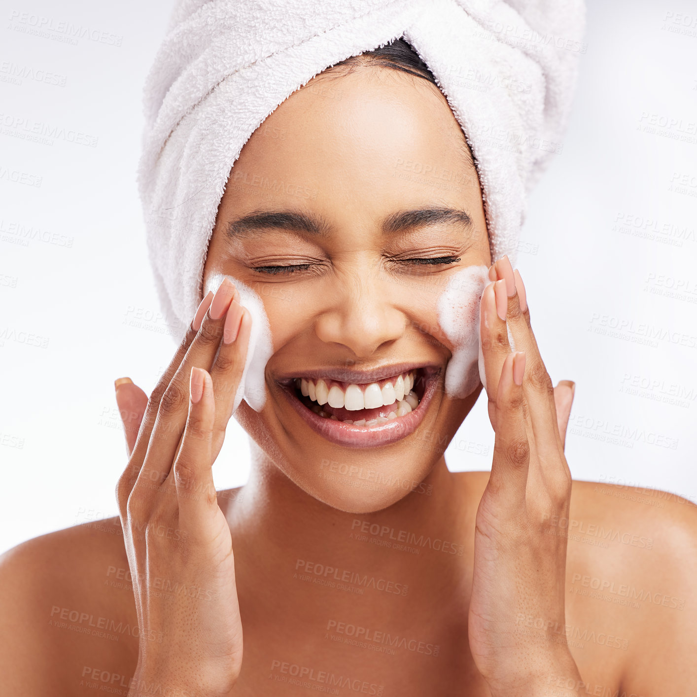 Buy stock photo Studio shot of a beautiful young woman washing her face against a white background